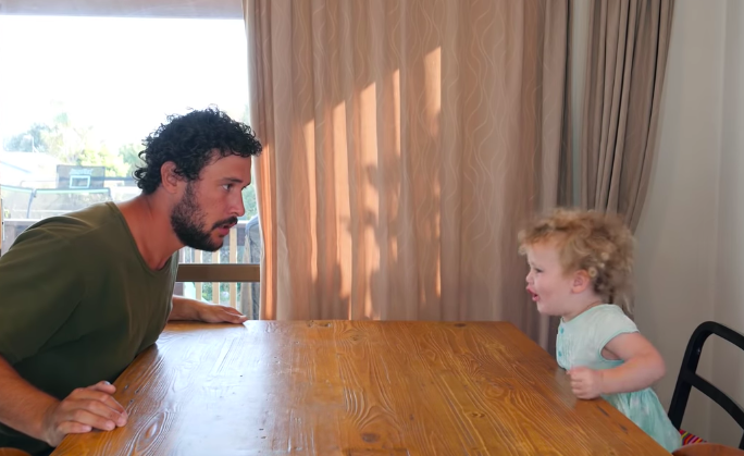 Le papa montre à sa petite fille comment chanter. Elle est hilarante et trop mignonne.